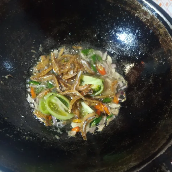 Masukkan ikan teri dan tomat hijau, beri air lalu bumbui dengan gula pasir dan kaldu bubuk, aduk rata dan koreksi rasanya lalu angkat dan sajikan.