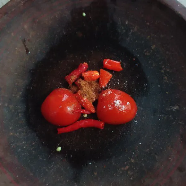 Masukkan tomat, cabai keriting, cabai rawit, gula merah sisir, dan garam dalam sebuah cobek.