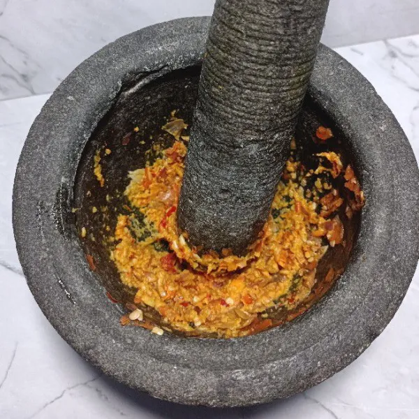 Haluskan bawang merah, bawang putih, kunyit, cabe keriting, cabe merah, kemiri dan jahe.