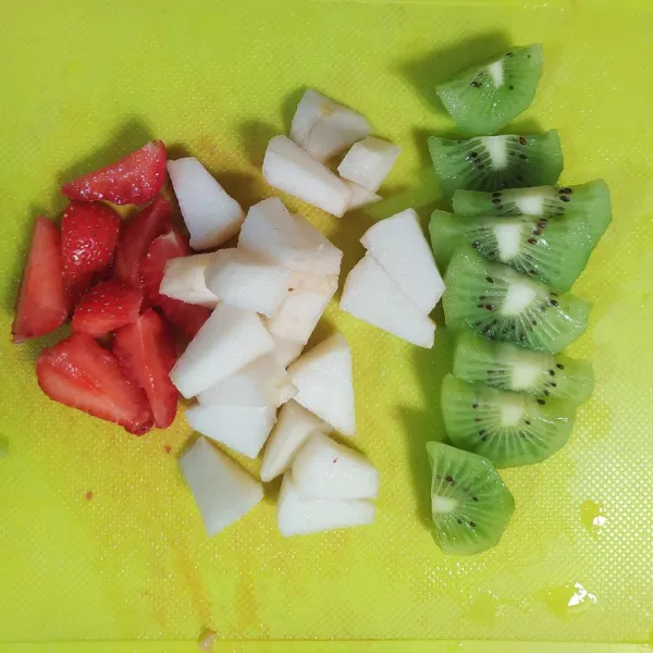 Potong-potong strawberry, pear dan kiwi.