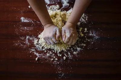 Adonan kue sedang diuleni dengan tepung