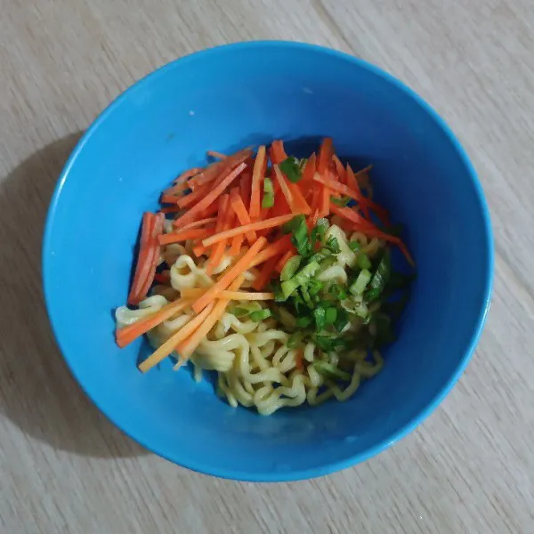 Potong wortel korek api dan iris daun bawang gabungkan bersama mie.