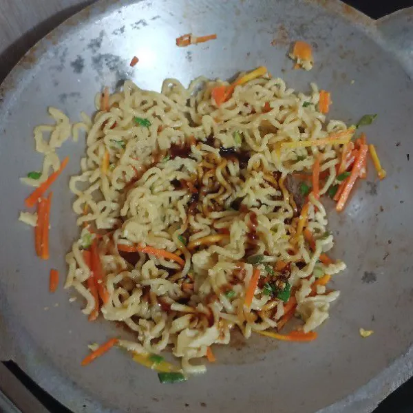 Tumis mie dalam sebuah wajan yang sudah panas, tumis sebentar, masukkan saus tiram, kecap manis, minyak wijen dan bumbu.