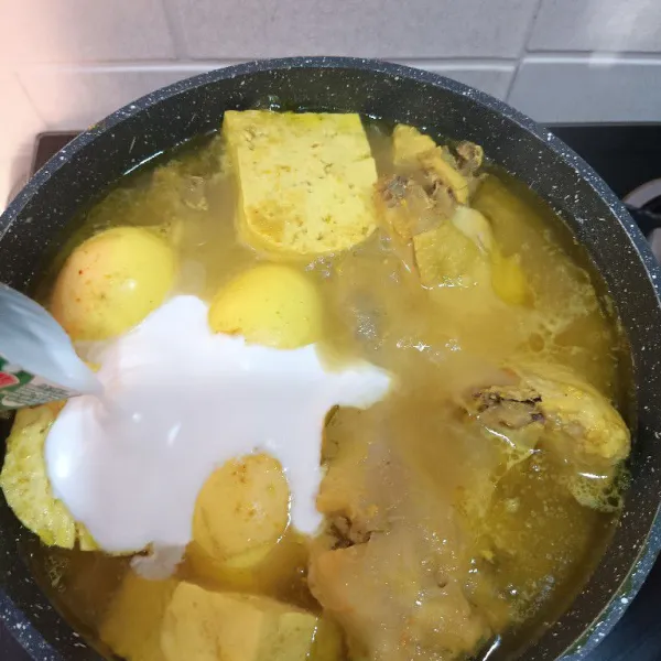 Selanjutnya tambahkan santan instan dan aduk hingga merata agar santan tidak pecah. Lalu matikan kompor, hasil kuningnya akan cantik.