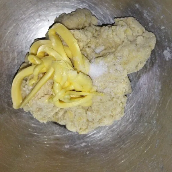 Masukkan air dan kuning telur, uleni hingga setengah kalis, tambahkan garam dan margarin, uleni hingga adonan kalis.
