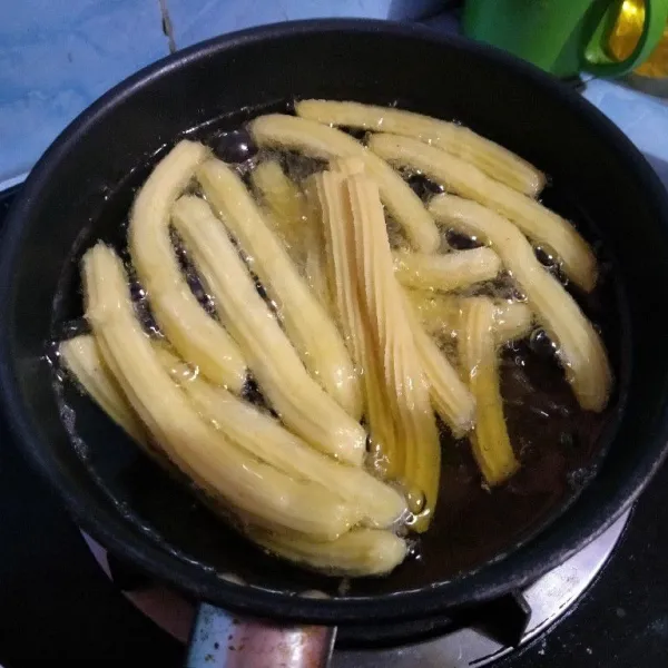 Panaskan minyak, tekan dan cetak churros di atas minyak langsung.