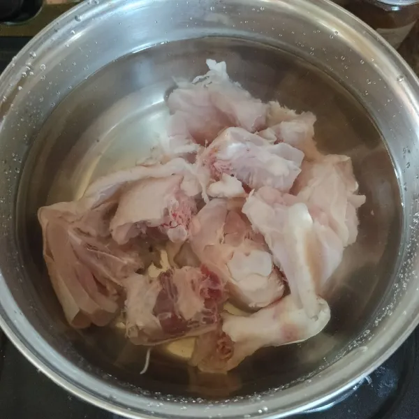 Rebus ayam dan air di dalam panci.