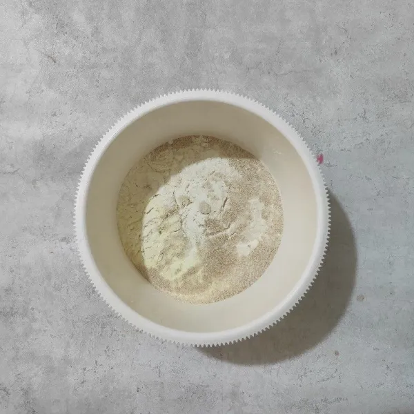 Siapkan wadah, masukkan tepung terigu, susu bubuk, gula pasir dan ragi lalu aduk rata.