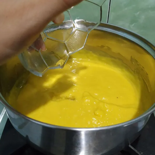 Campur gelatin yang telah mengembang lalu tambahkan air mendidih. Masukkan gelatin ke dalam adonan mangga lalu aduk rata.