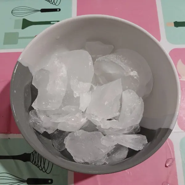 Remukkan es batu, masukkan di mangkok saji.