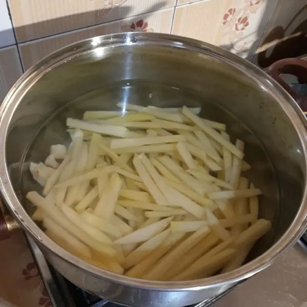 Didihkan air dengan garam dan bawang putih geprek, lalu masukkan potongan kentang, rebus selama 6 menit lalu angkat dan tiriskan.