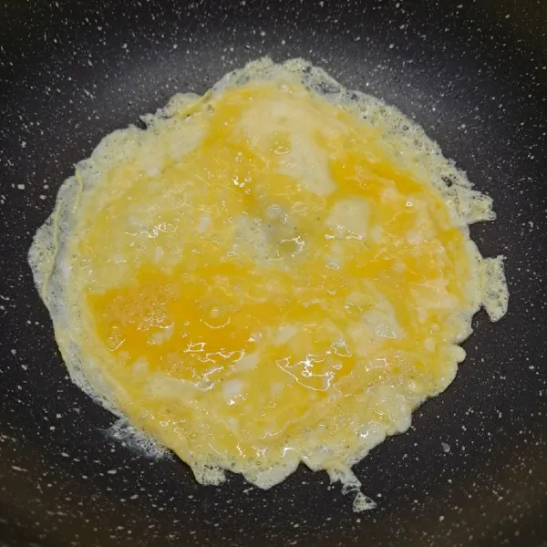 Kocok telur dengan sedikit garam sampai rata. Panaskan sedikit minyak goreng, kemudian tuang telur kocok. Buat dadar telur, masak sampai matang. Angkat dan gulung, kemudian iris telur dadar lalu sisihkan.