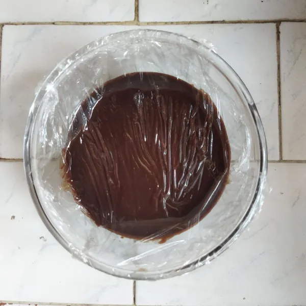 Pindahkan lelehan coklat ke dalam mangkuk, lalu tutup permukaannya menggunakan plastik wrap. simpan dalam kulkas selama 3 jam.