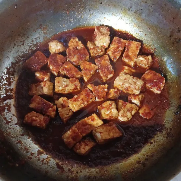 Masukkan tempe, aduk rata, masak hingga air dan bumbu meresap, matikan api
