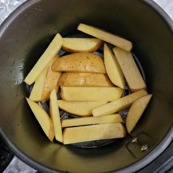 Panggang kentang dengan menggunakan air fryer dengan suhu 180°C selama 25 menit.
