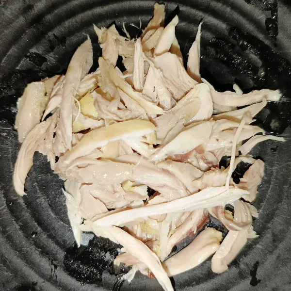 Angkat ayam dari panci dan suwir-suwir dagingnya setelah mulai dingin.