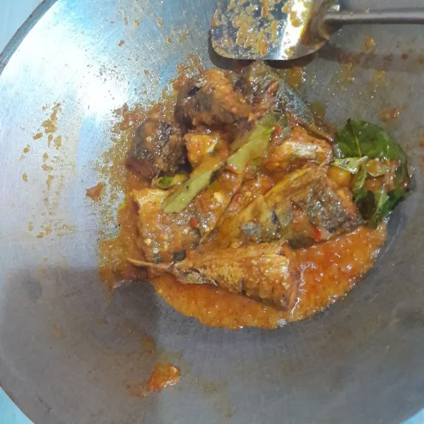 Setelah bumbu matang, masukkan ikan yang sudah digoreng lalu tambahkan air secukupnya dan beri garam, penyedap rasa dan gula pasir, aduk hingga rata dan masak hingga air menyusut.