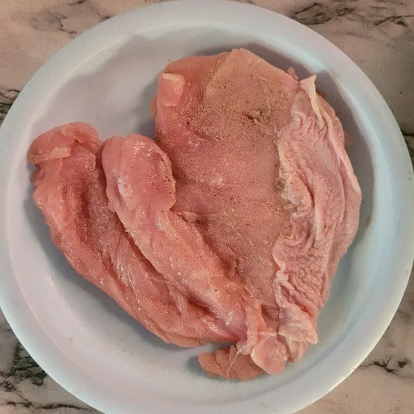 Fillet dada ayam kemudian pukul-pukul daging ayam supaya lebih lunak, kemudian marinasi selama 10 menit dengan menggunakan garam dan lada bubuk.