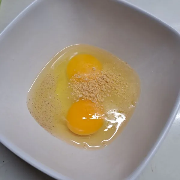 Kocok telur, kaldu bubuk dan merica bubuk sampai rata.