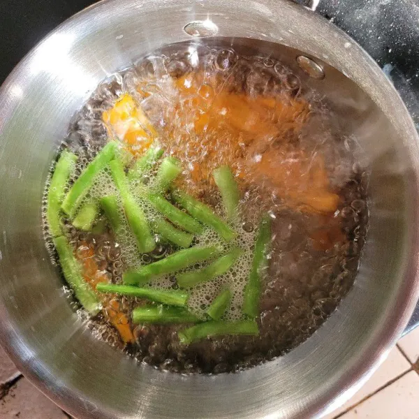 Cuci bersih dan potong-potong wortel dan buncis, kemudian rebus dengan air yang telah diberi sedikit garam hingga matang.