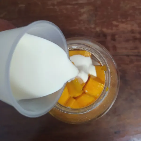 Masukkan buah mangga dan whipping cream ke dalam blender.