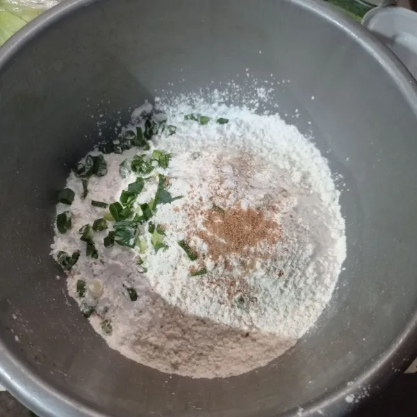 Buat cilok, masukkan tepung terigu, tepung kanji, daun bawang, bawang putih halus, garam, lada dan kaldu bubuk ke dalam wadah.