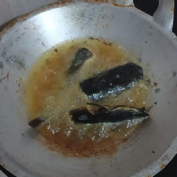 Panaskan wajan hingga mengebul, tuang minyak. Setel api sedang , taburkan tepung terigu. Masukkan lele, saat terdengar suara daging lele agak meletus, tambahkan kembali tepung. Goreng hingga lele kering. Lele tidak perlu dibolak-balik, sehingga pastikan minyaknya cukup untuk merendam satu sisi lele.