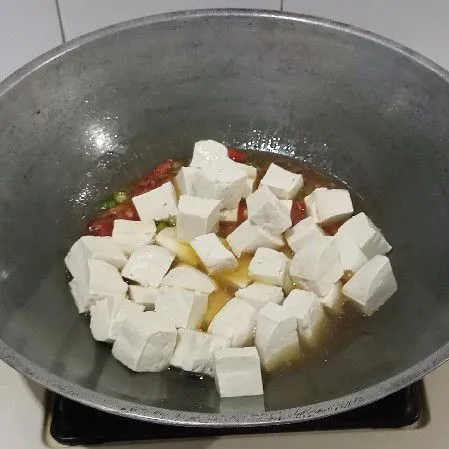 Masukkan tahu, aduk rata perlahan, masak sampai bumbu menyerap.