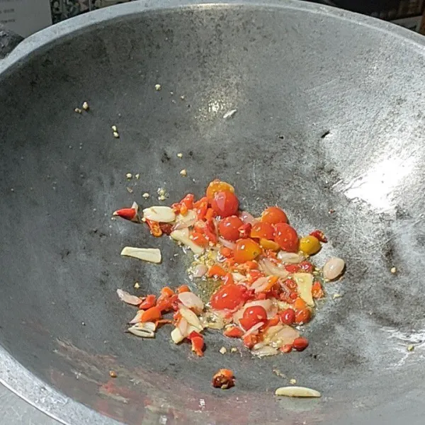 Tumis bawang merah dan bawang putih hingga harum, tambahkan cabai dan tomat, oseng sebentar.