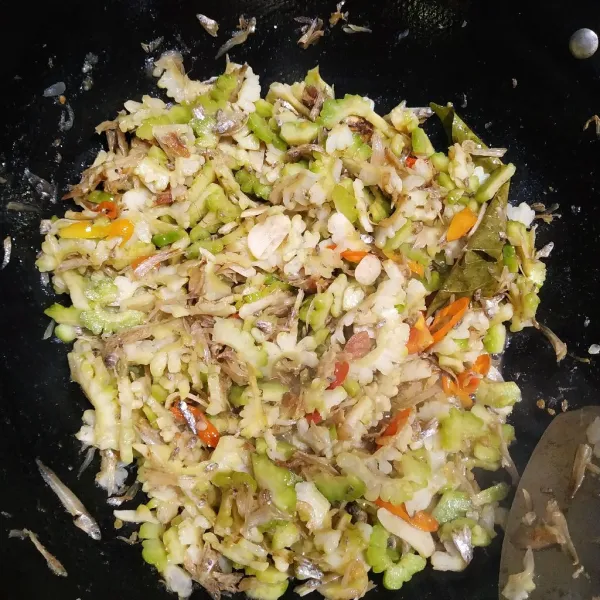 Tambahkan air, garam, gula dan kaldu bubuk lalu koreksi rasa. Masukkan pare lalu masak hingga bumbu meresap dan matang lalu angkat dan sajikan.