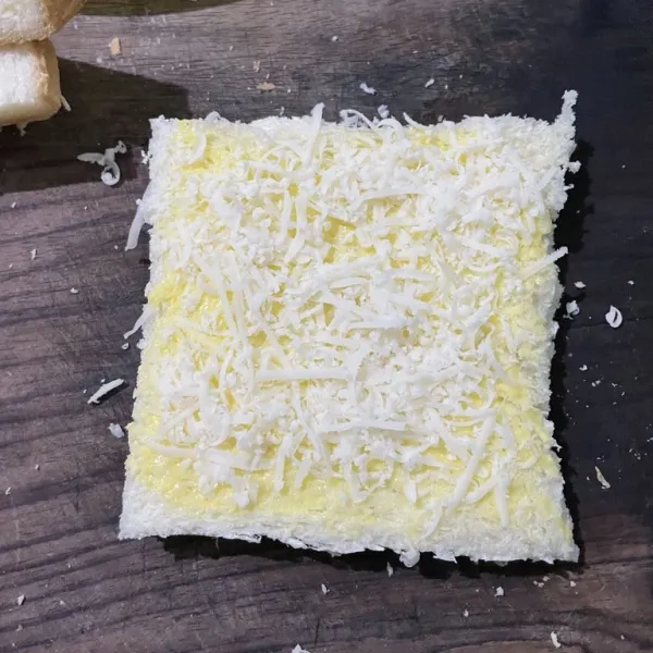 Oles mentega dan beri keju parut.