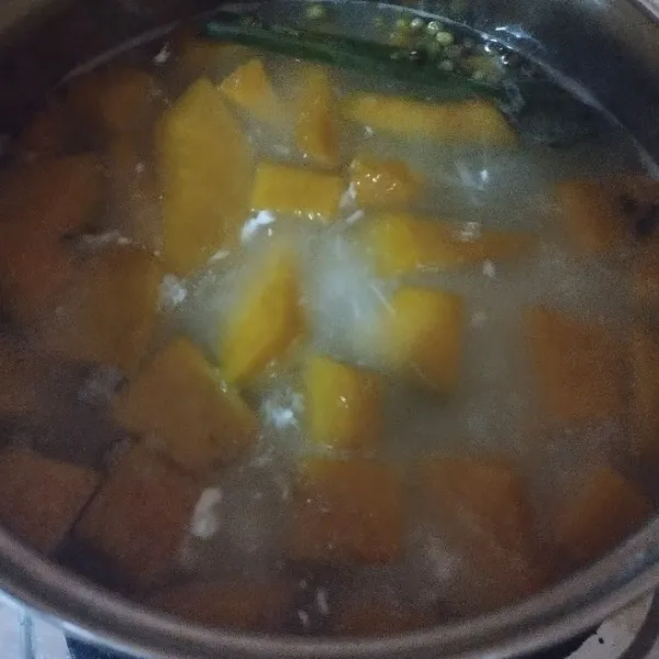 Setelah mendidih masukkan santan instan aduk rata. Masak lagi sampai labu kuning empuk.