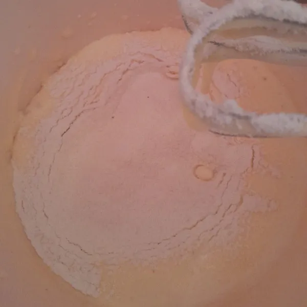 Masukkan tepung yang telah diayak, mixer dengan kecepatan rendah, setelahnya masukkan minyak goreng.