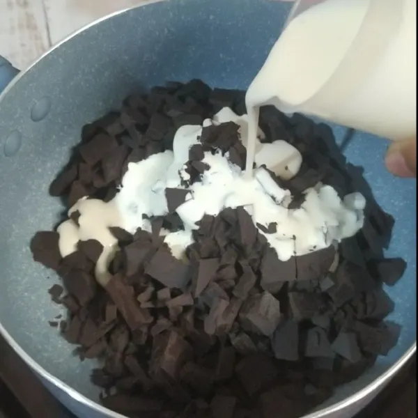 Masukkan potongan cokelat dan krim segar ke dalam panci.