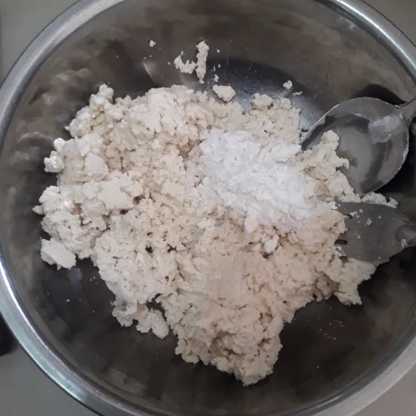 Taruh tahu ke dalam mangkuk lalu hancurkan menggunakan garpu, tambahkan tepung beras dan aduk sampai tercampur rata.