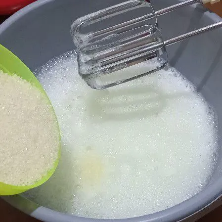 Tuang gula pasir secara bertahap mixer dengan speed tinggi sampai mengembang kental berjejak.