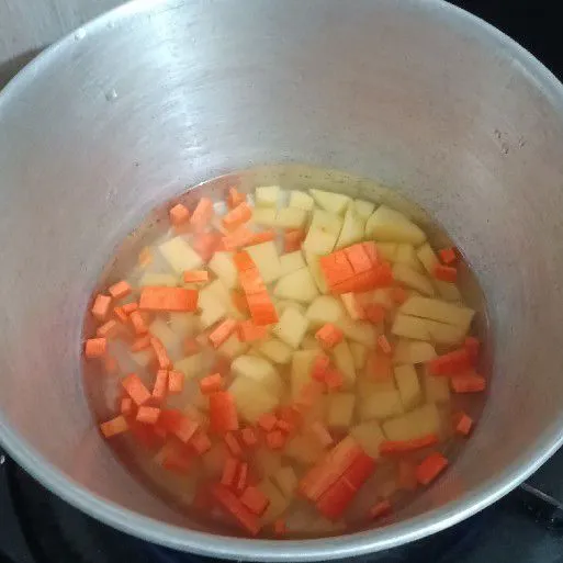 Rebus kentang dan wortel yang dipotong kecil hingga matang.