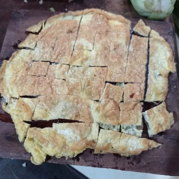 Kocok lepas telur dan kaldu bubuk lalu goreng sampai kedua sisi matang, angkat dan potong kecil-kecil.