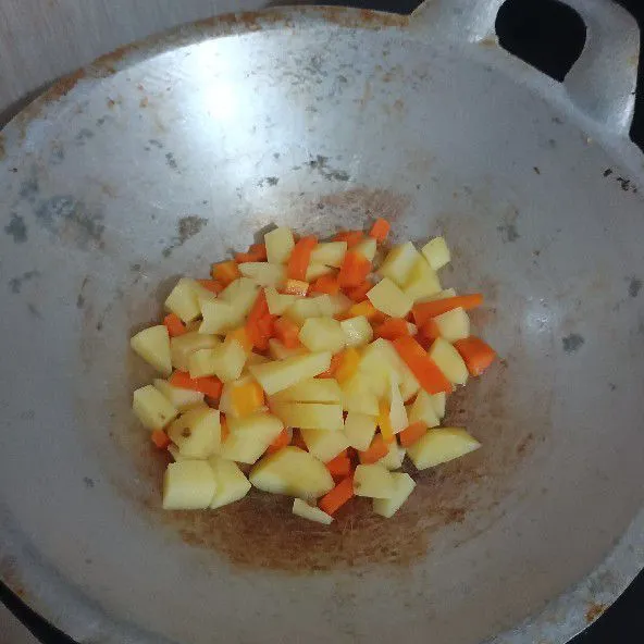 Tambahkan kentang dan wortel yang sudah direbus dan dipotong kecil kotak.
