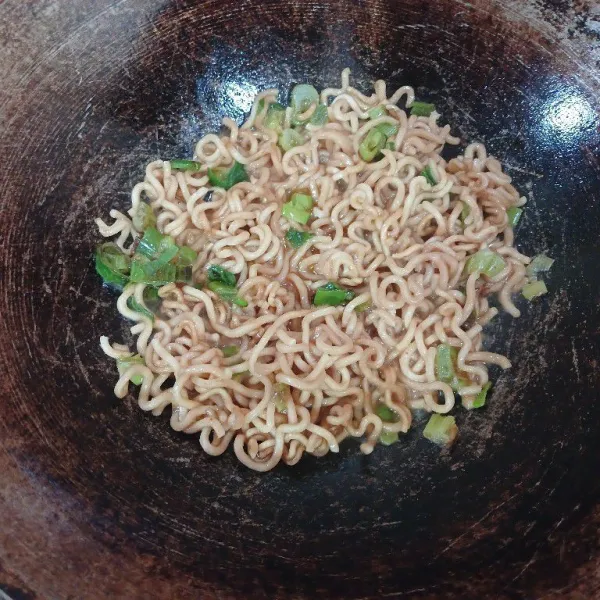 Masukkan mie instan yang sudah direbus sebelumnya, masukkan bumbu penyertanya kemudian aduk rata.