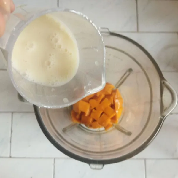 Masukkan buah mangga, madu, dan whipping cream ke dalam blender, kemudian blender hingga halus.