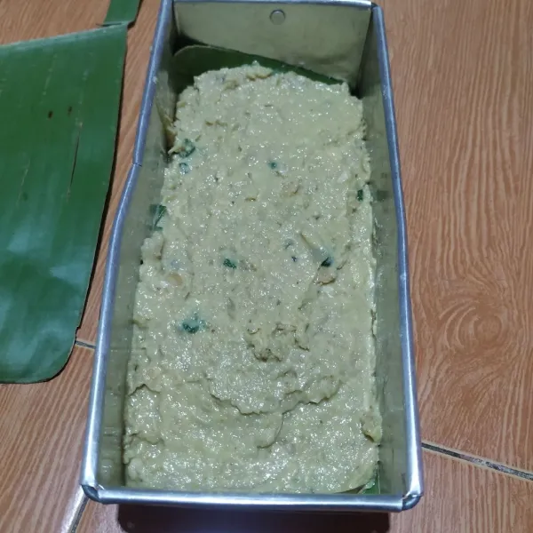 Masukkan ke dalam loyang yang sudah diberi alas daun pisang dan diolesi minyak goreng.