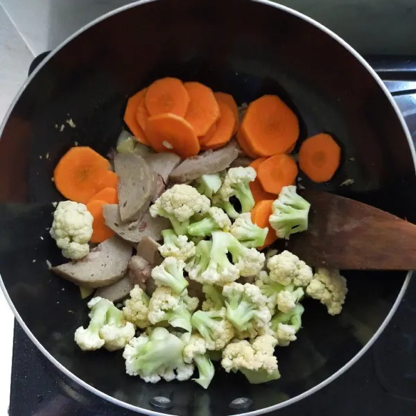 Masukkan kembang kol, wortel dan bakso, lalu aduk rata.