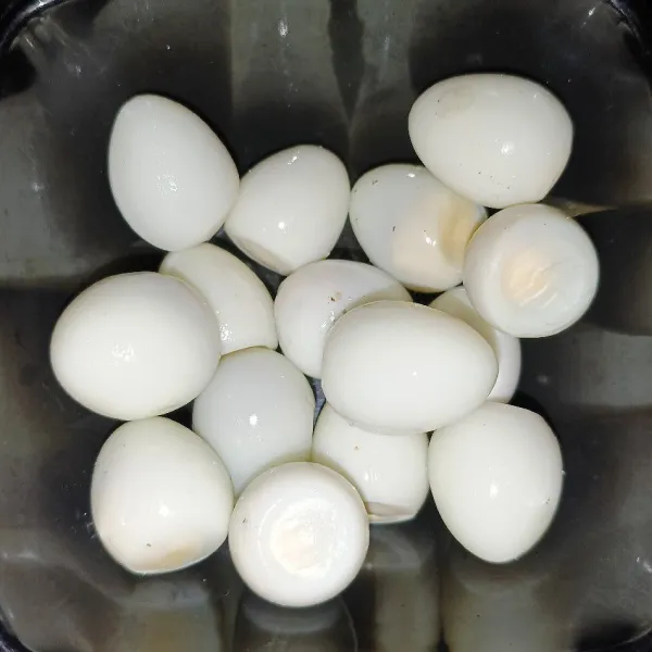 Rebus telur puyuh sampai matang lalu kupas kulitnya.