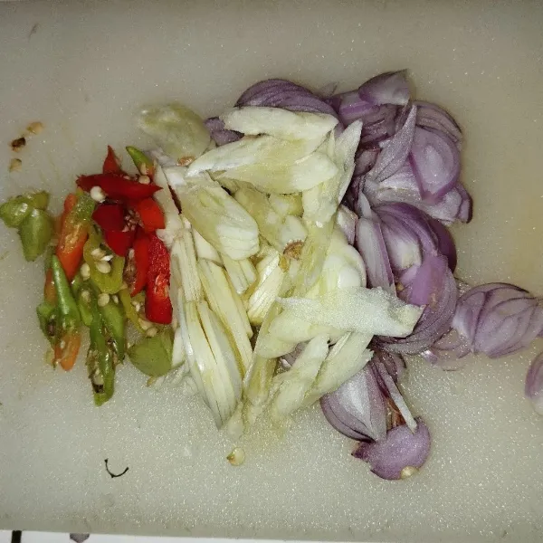 Iris tipis bawang putih, bawang merah, dan cabe rawit.