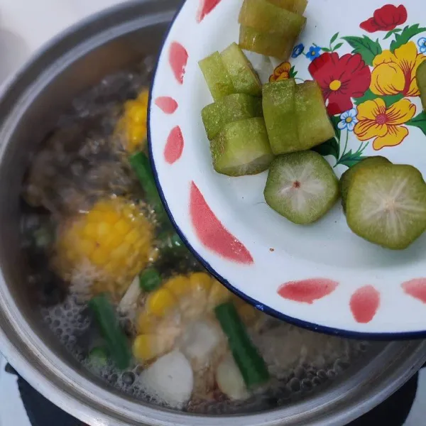 Ketika kacang panjang mulai matang, masukkan irisan belimbing wuluh lalu masak hingga layu.