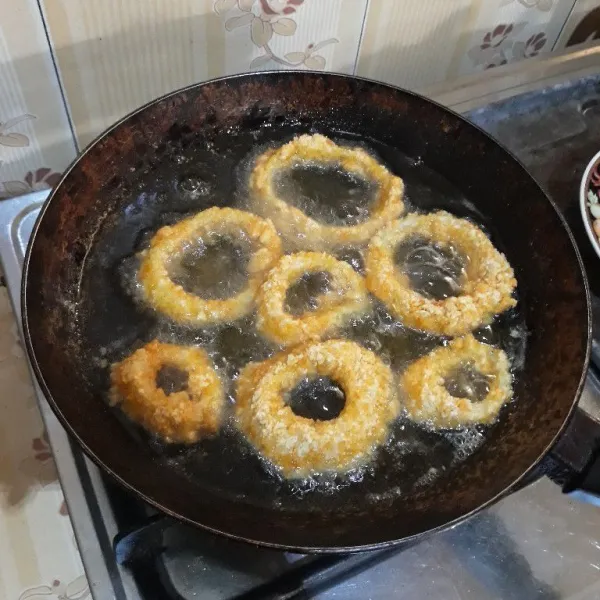 Setelah 30 menit, goreng bawang bombay di dalam minyak yang sudah dipanaskan hingga garing dan kecokelatan. Angkat dan tiriskan, onion ring siap disajikan.