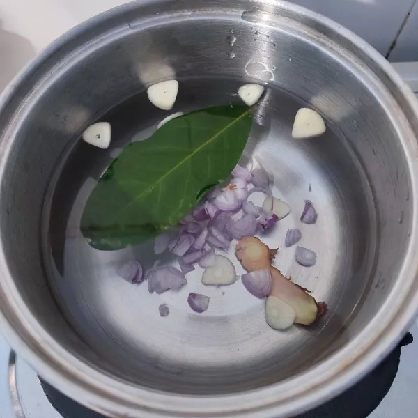 Rebus air, irisan bawang merah, irisan bawang putih, lengkuas dan daun salam hingga mendidih.