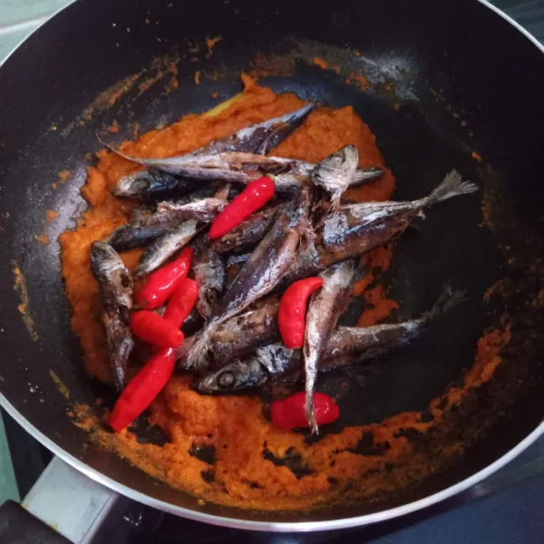 Masukkan ikan pindang, cabe utuh kemudian bumbui dengan gula dan garam lalu tuang air.