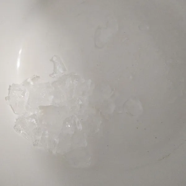 Hancurkan es batu, kemudian masukkan ke dalam wadah.